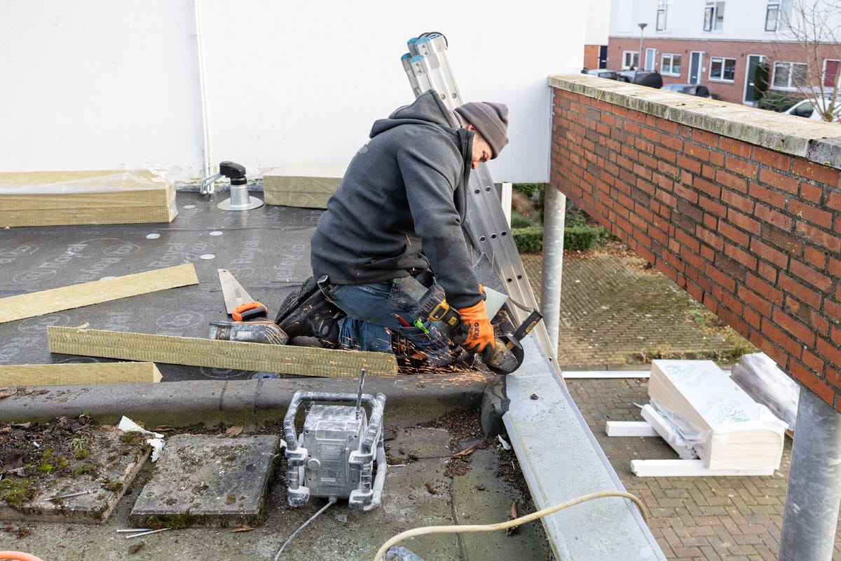 Dakdekker van Twintop bewerkt zinken dakgoot op een plat dak